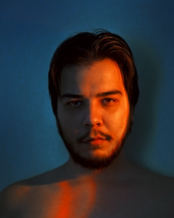 A warm, professional portrait of Ismaelfonss in a dark, softly blurred background with subtle blue highlights.