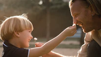 A therapist gently engaging with a child during a playful therapy session.
