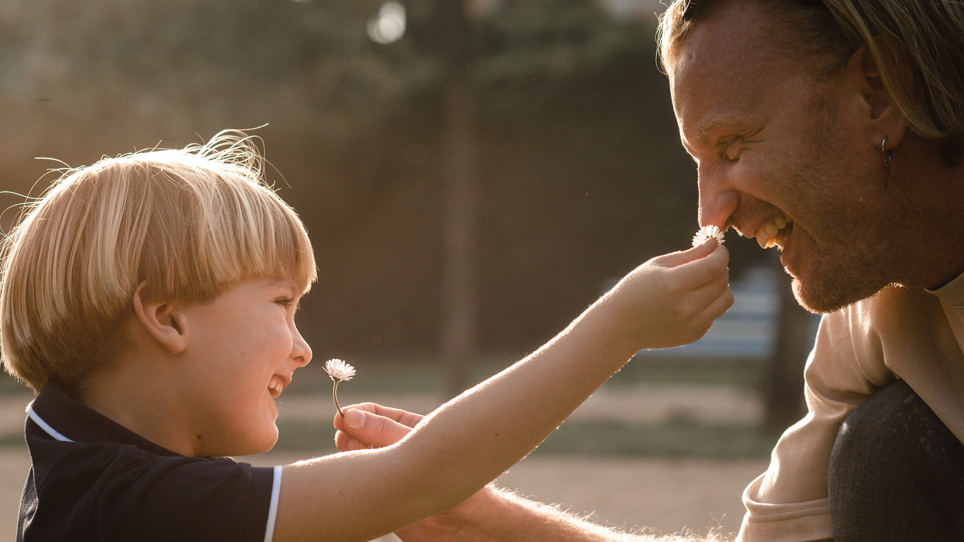 a man feeding a young boy a piece of cake