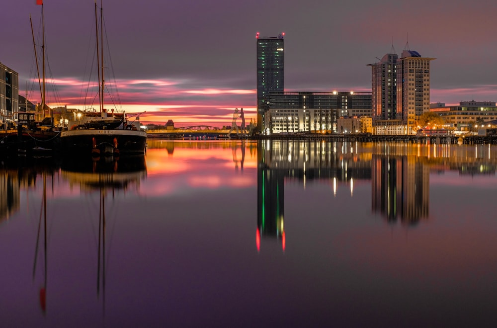 a city skyline is reflected in the water