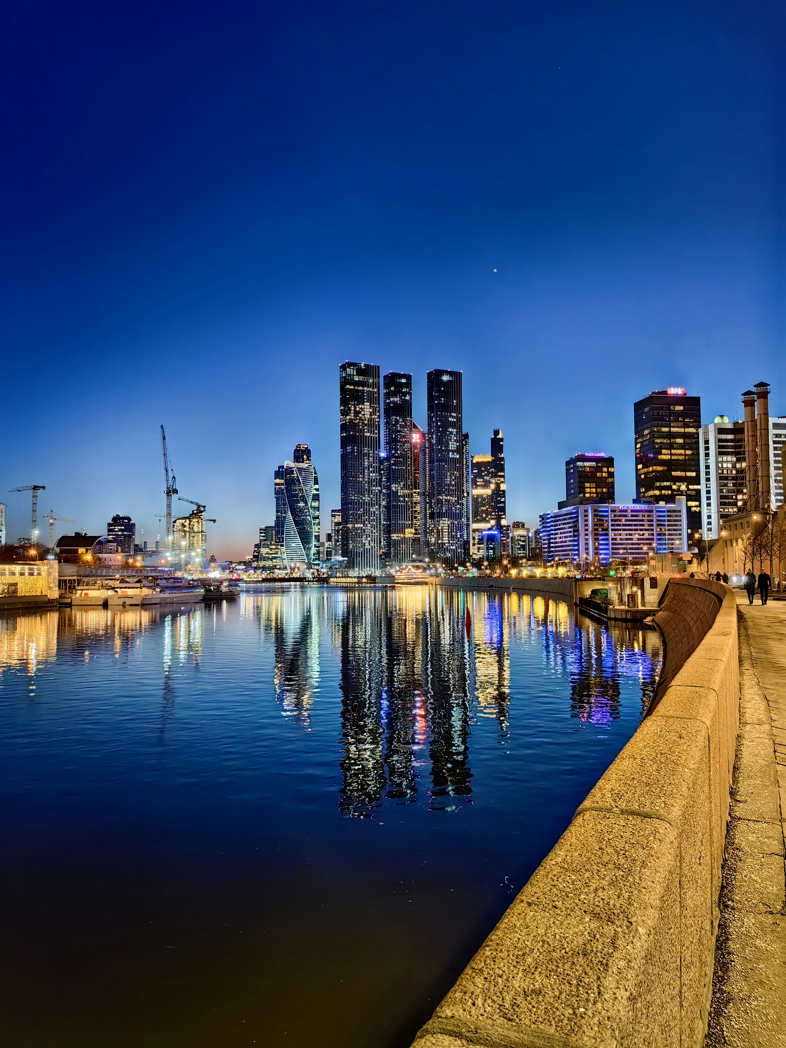 Modern German city skyline at dusk, Rhine river reflection, cool blue tones, urban infrastructure