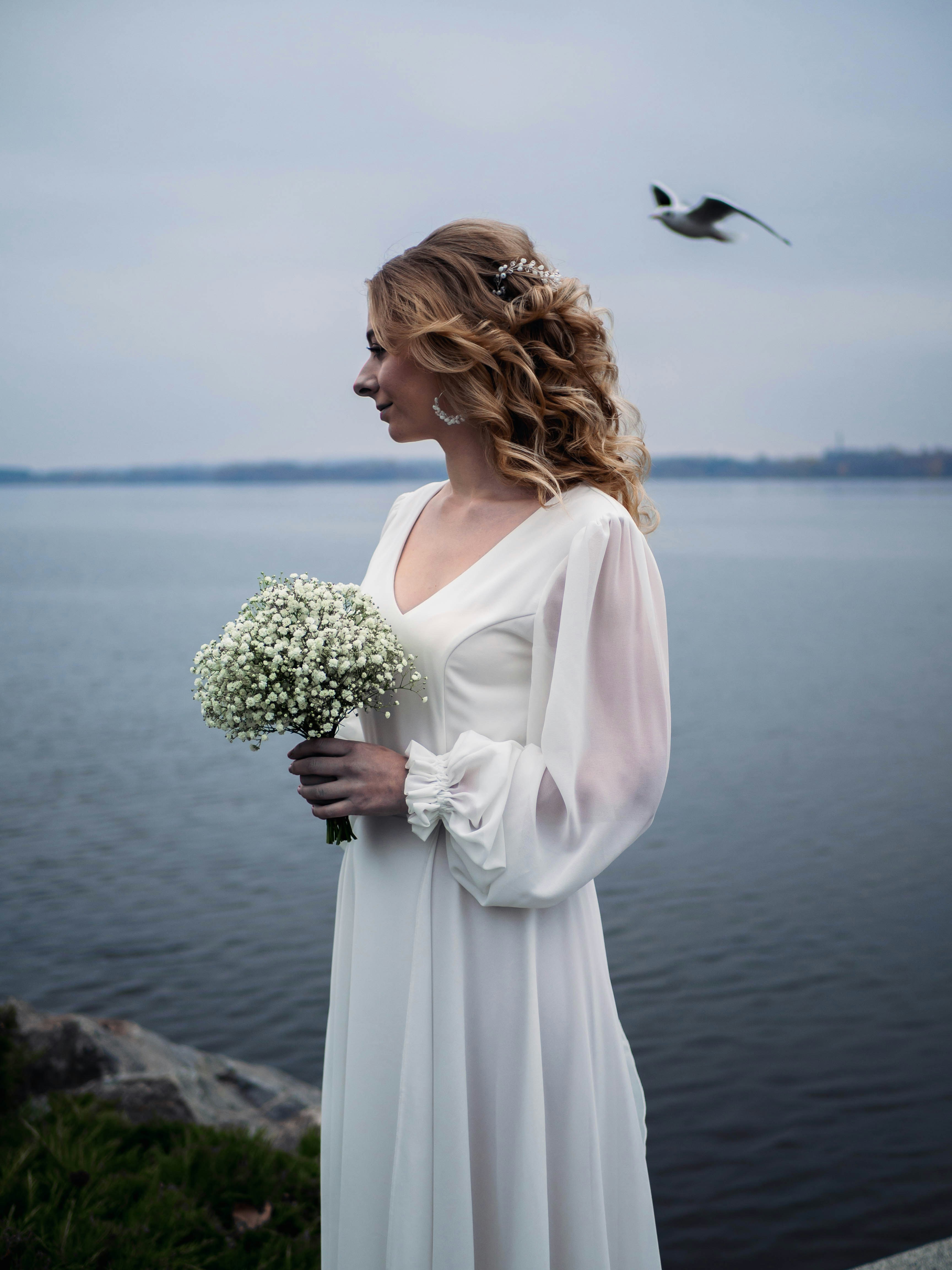 a woman in a white dress holding a bouquet of flowers