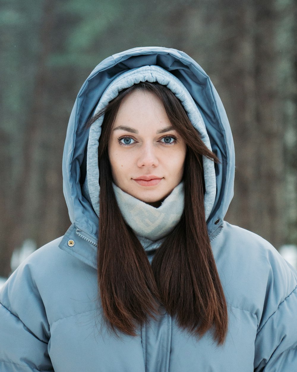 a woman wearing a blue jacket and a white scarf