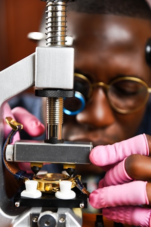 Close-up of hands adjusting a high-tech medical manufacturing device.