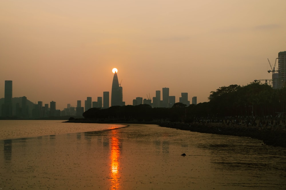 the sun is setting over the city skyline