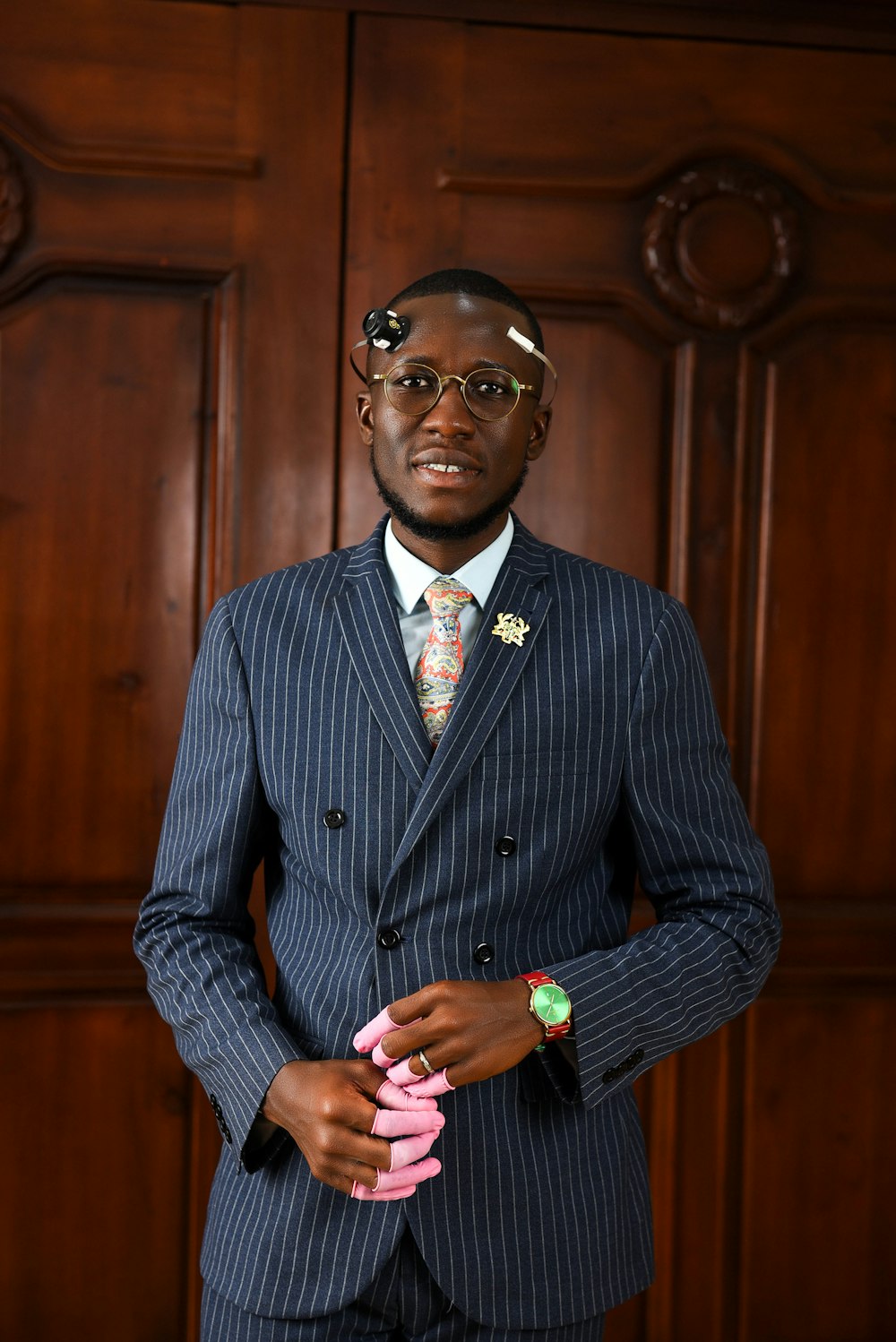 a man in a suit standing in front of a wooden door