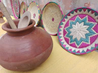 Clay pots and natural oils displayed on woven baskets, evoking ancient healing traditions.