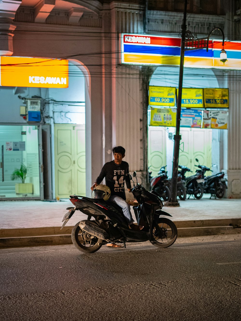 a man riding a motorcycle down a street at night