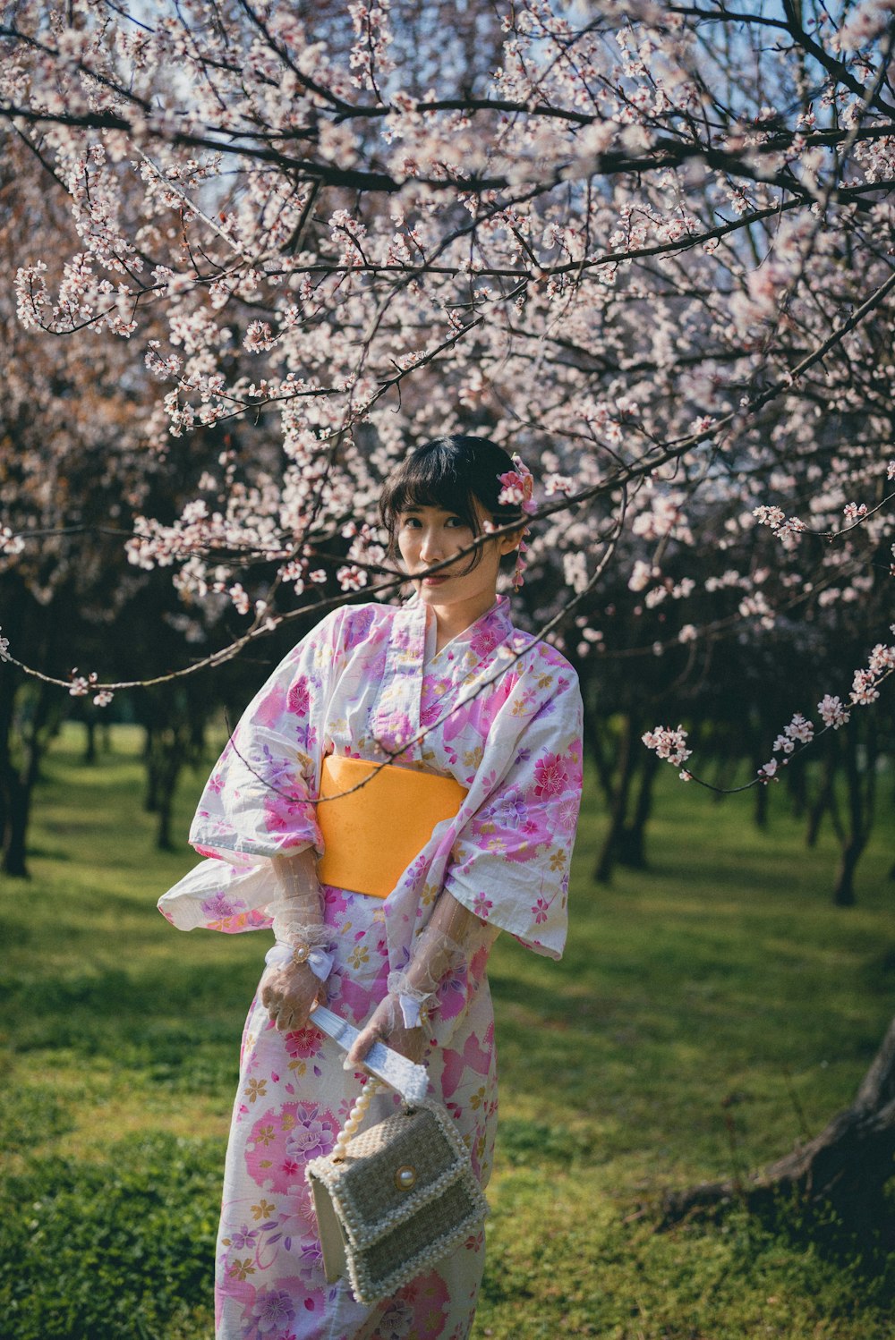 a woman in a kimono is holding a basket