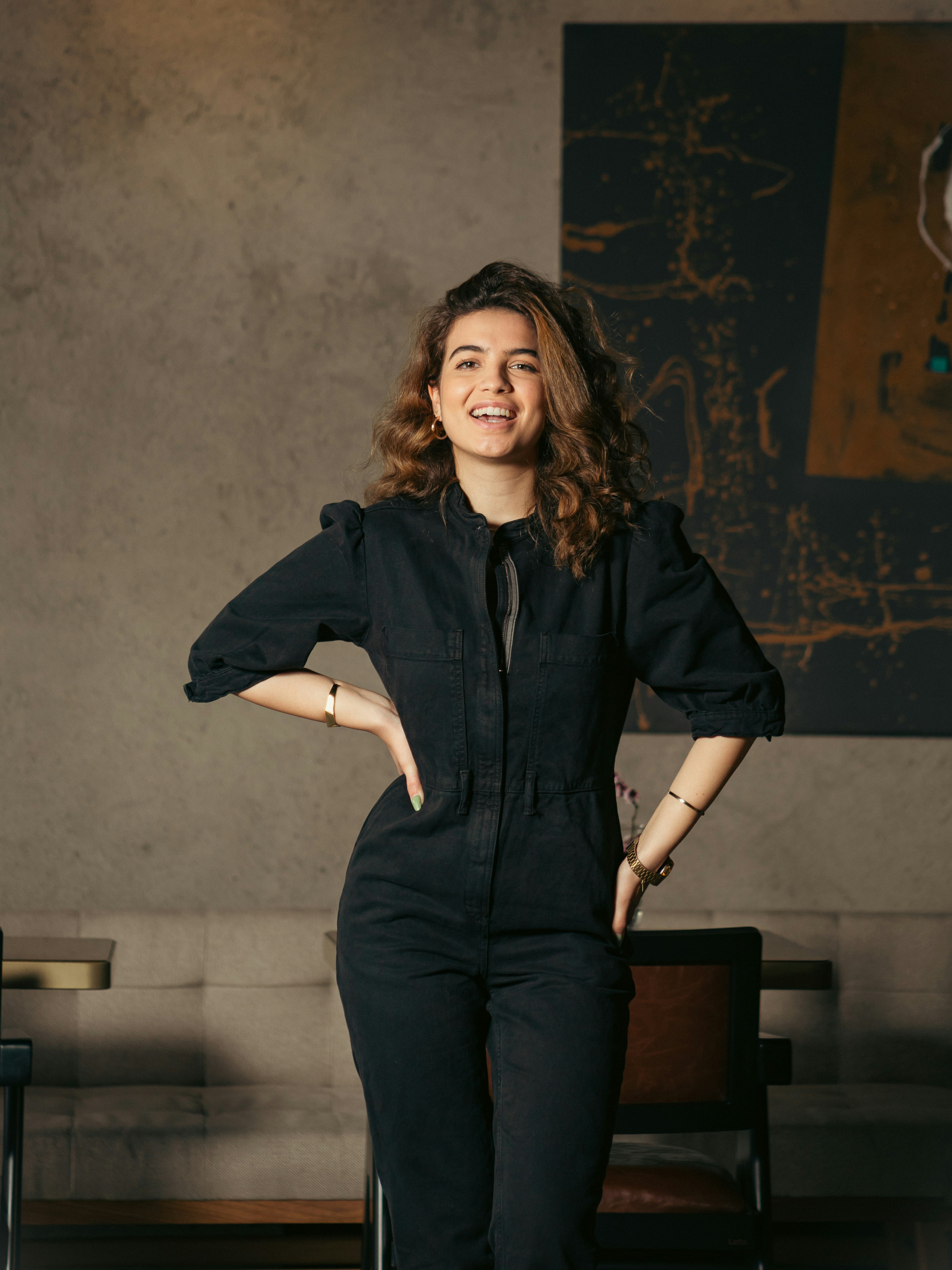 a woman in a black jumpsuit posing for a picture
