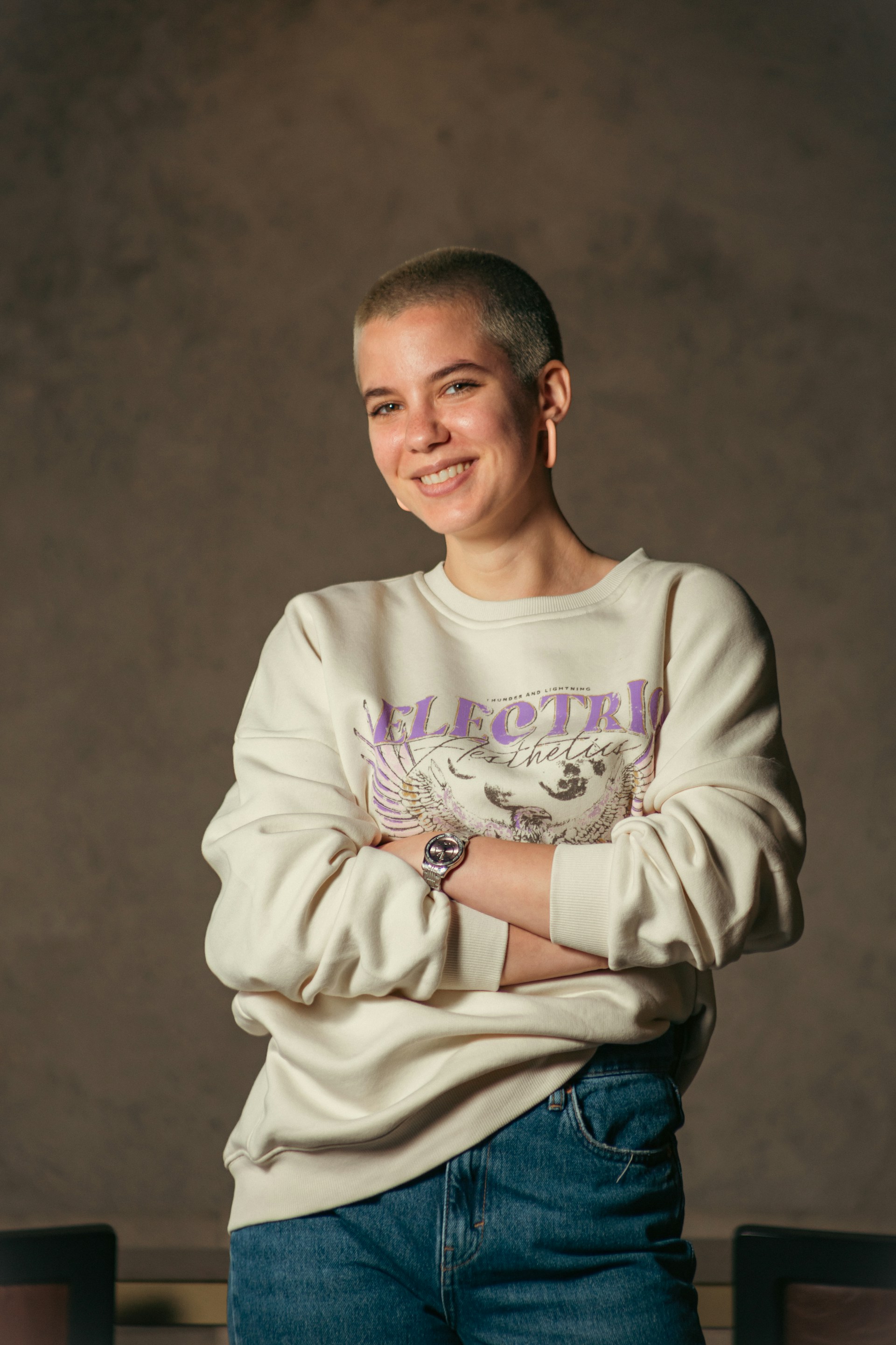 a woman with her arms crossed posing for a picture