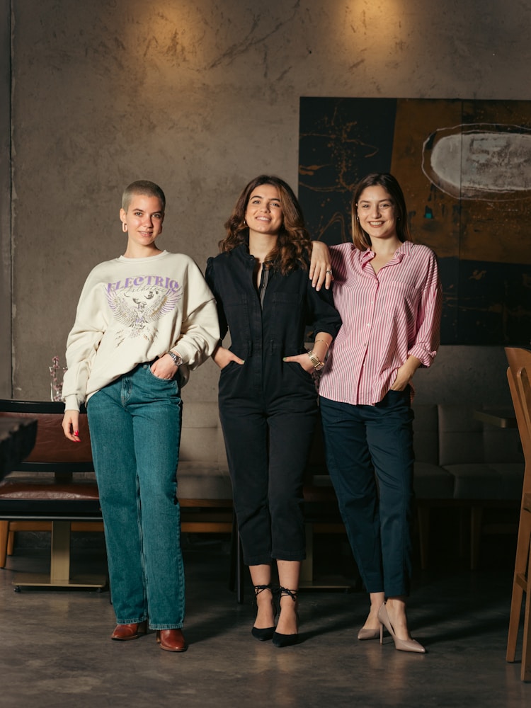 a group of three women standing next to each other