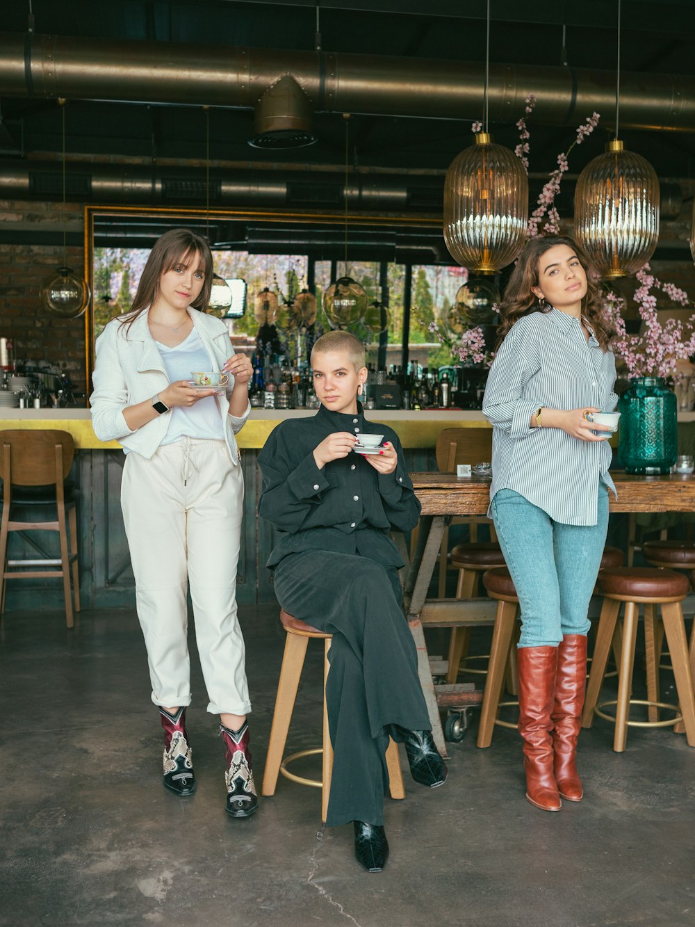Tres mujeres de pie y sentadas en una mesa