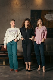 a group of three women standing next to each other