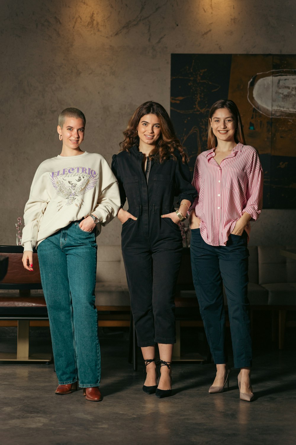 a group of three women standing next to each other