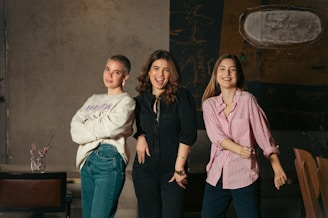 a group of three women standing next to each other