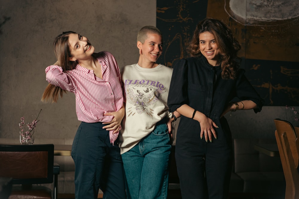 a group of three women standing next to each other