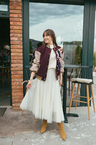 a woman in a white dress and a maroon jacket