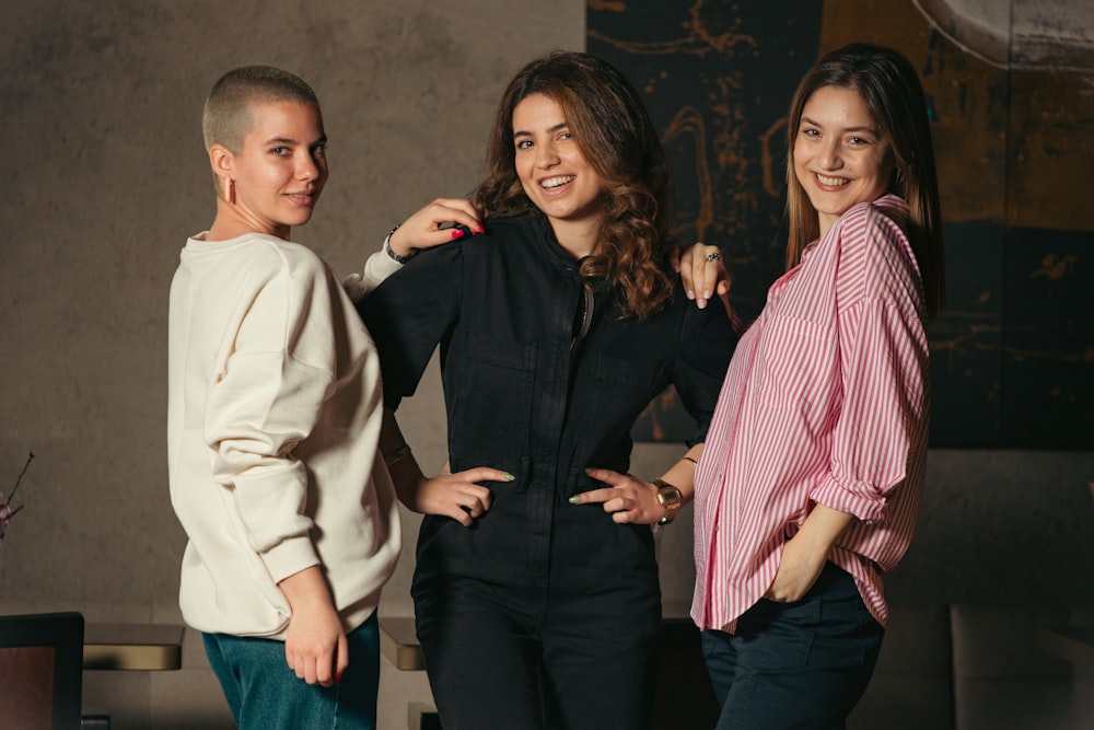 a group of three women standing next to each other