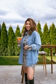 a woman standing on a patio holding a drink