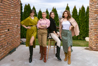 A diverse group of confident women in Air Force uniforms sharing a moment of camaraderie outdoors.