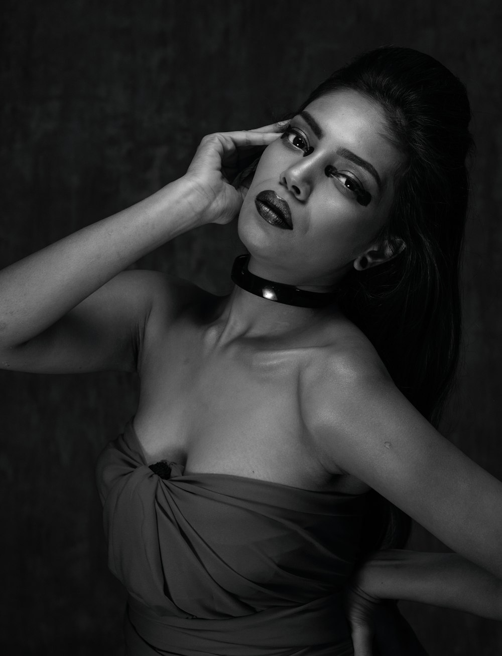 a woman in a strapless dress poses for a black and white photo