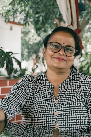 a woman wearing glasses and a black and white checkered shirt