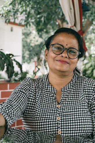 a woman wearing glasses and a black and white checkered shirt