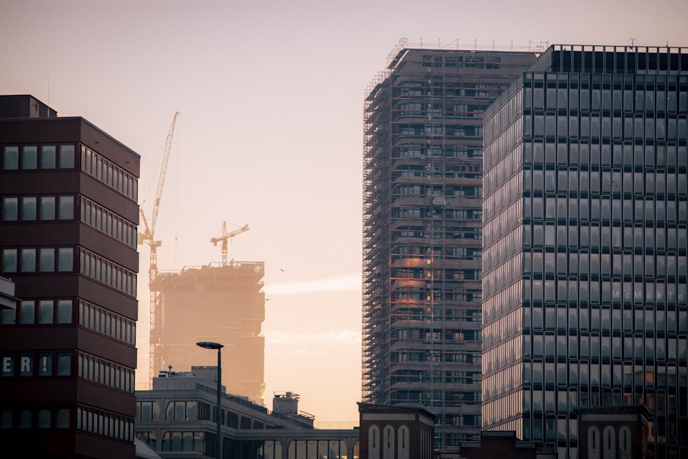 a city skyline with tall buildings and cranes