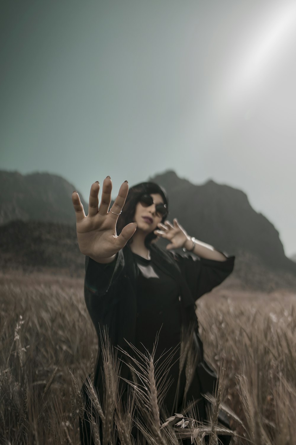 a woman standing in a field of tall grass