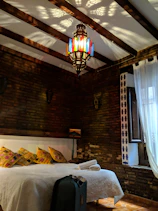 Elegant Moroccan bedroom with warm terracotta walls and intricate lantern lighting.