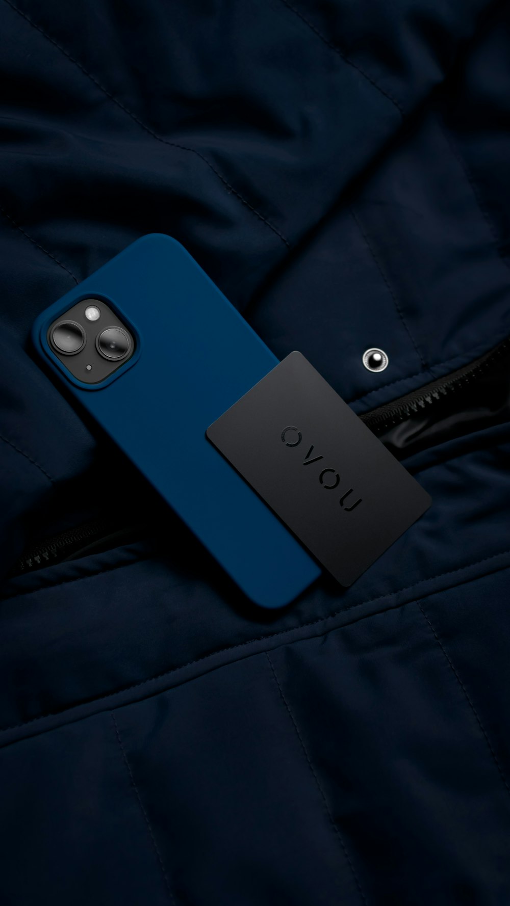 a cell phone laying on top of a blue jacket