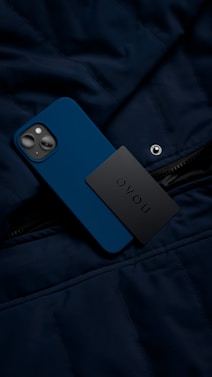 a cell phone laying on top of a blue jacket