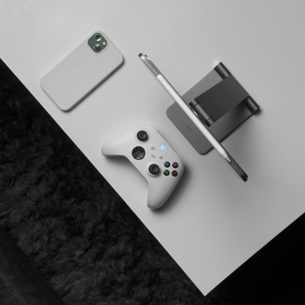 une table blanche avec un contrôleur blanc et un téléphone portable