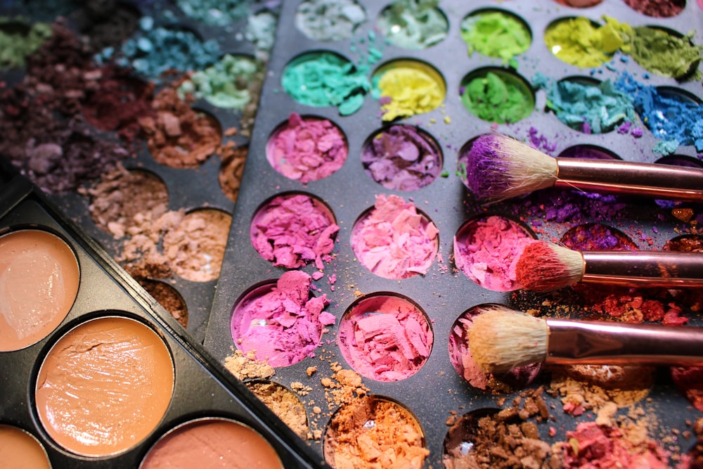 a close up of a palette of makeup and brushes