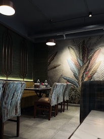 Cozy dining area bathed in warm golden and blue lighting with green accents.