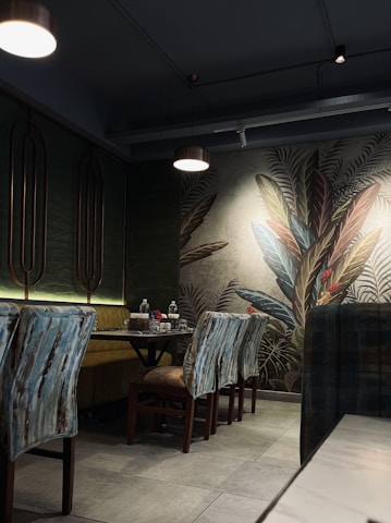 Cozy dining area bathed in warm golden and blue lighting with green accents.