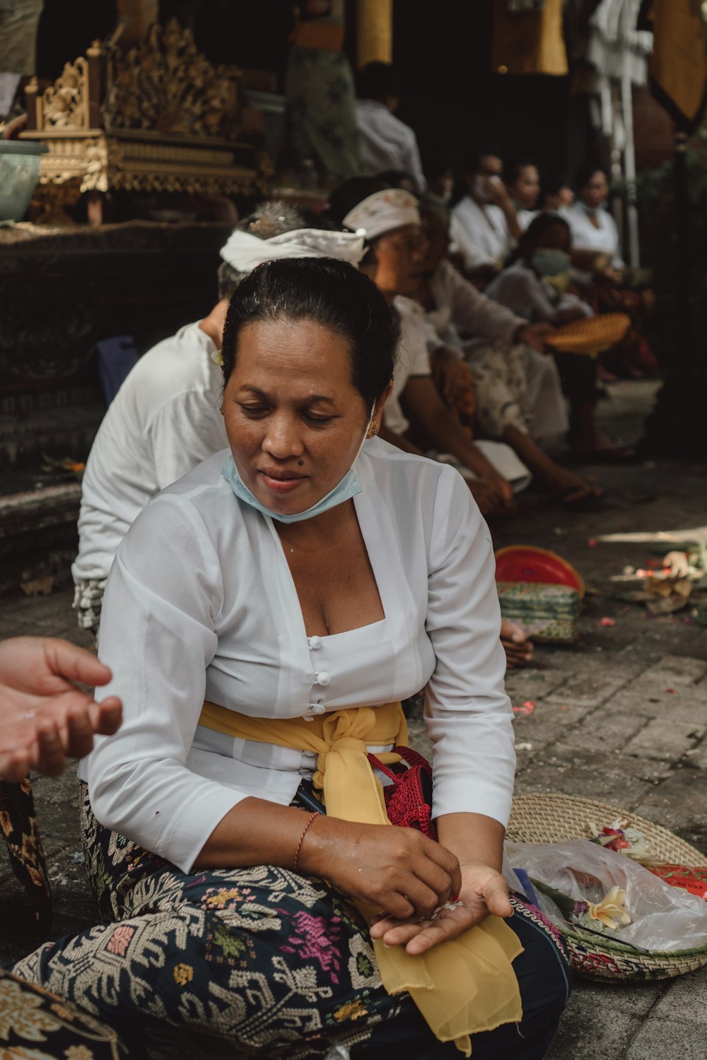 a woman sitting on the ground in front of a group of people