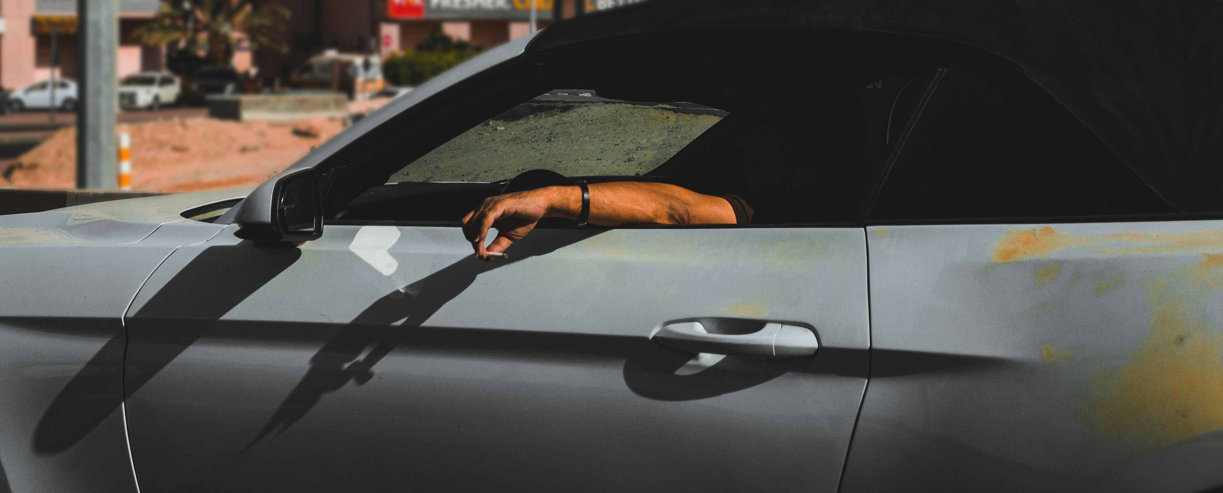 a hand sticking out of the window of a car