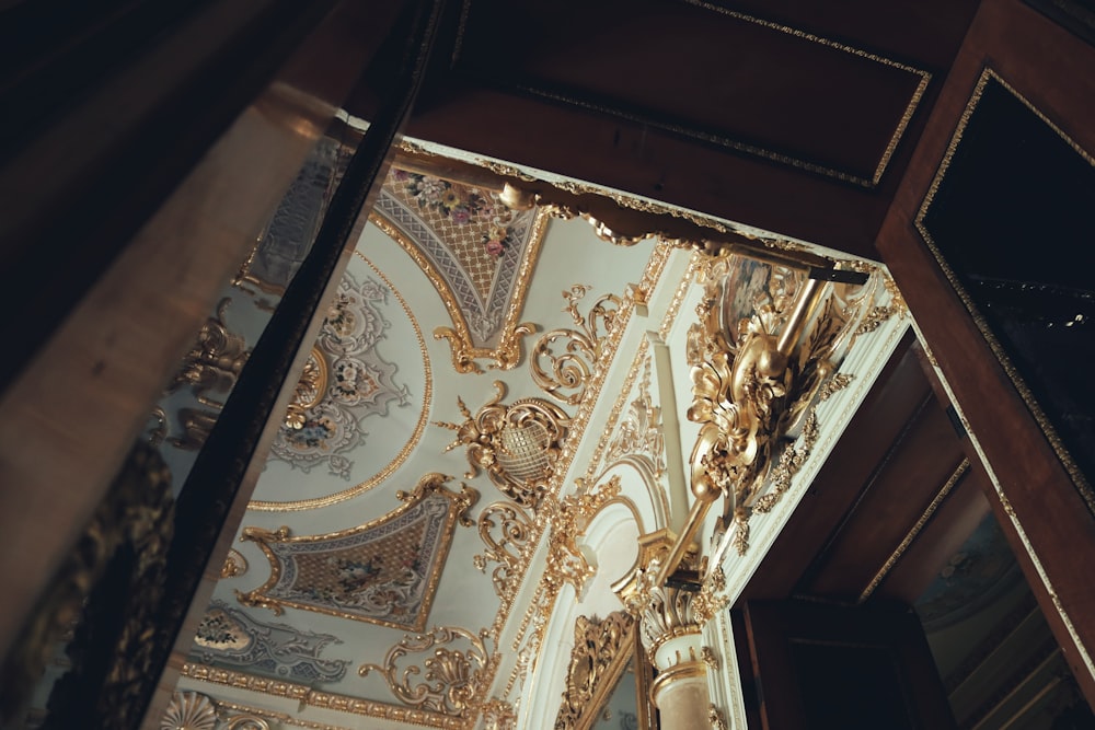 the ceiling of a building with gold decorations on it