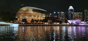 Night view of a city skyline lit up in gold, reflecting the sophisticated travel experience offered.