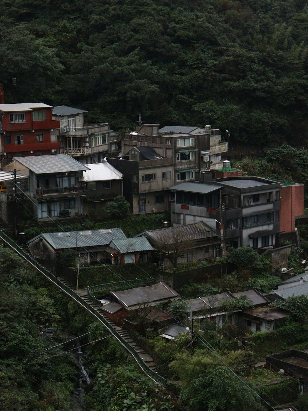 a group of houses sitting on top of a lush green hillside