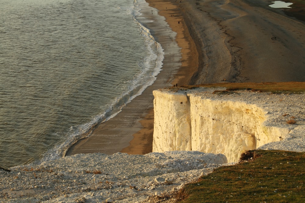 a person standing on the edge of a cliff next to the ocean