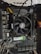 A computer motherboard with an AMD CPU cooler prominently displayed. The board includes various components such as RAM slots, power connectors, and a graphics card. The wiring is visible, with colored cables neatly arranged.