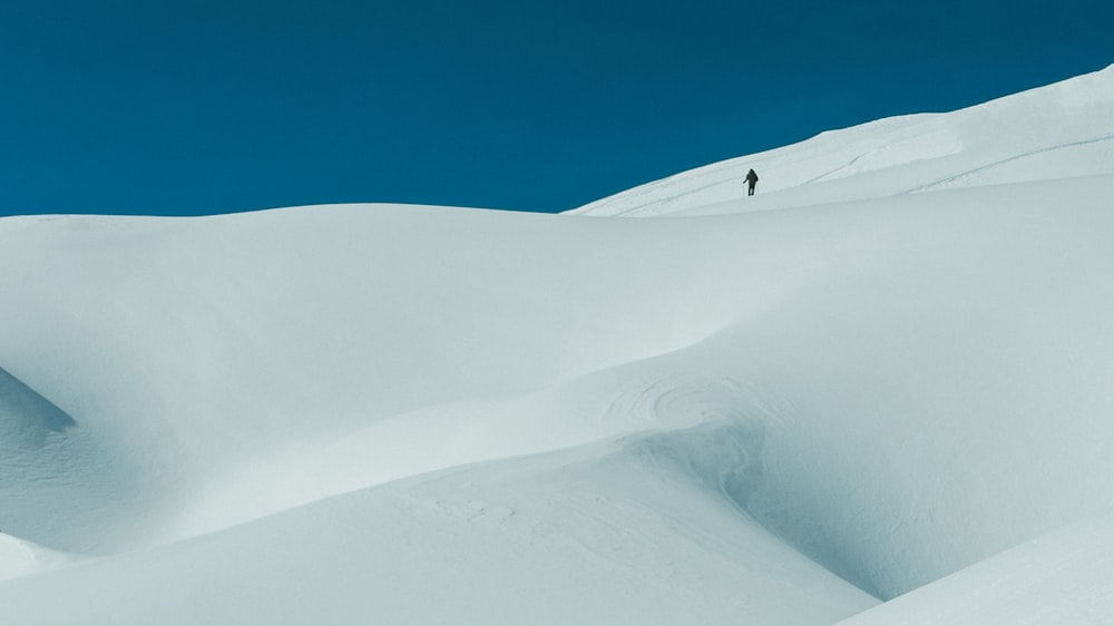 Un hombre montando esquís por la ladera de una pendiente cubierta de nieve