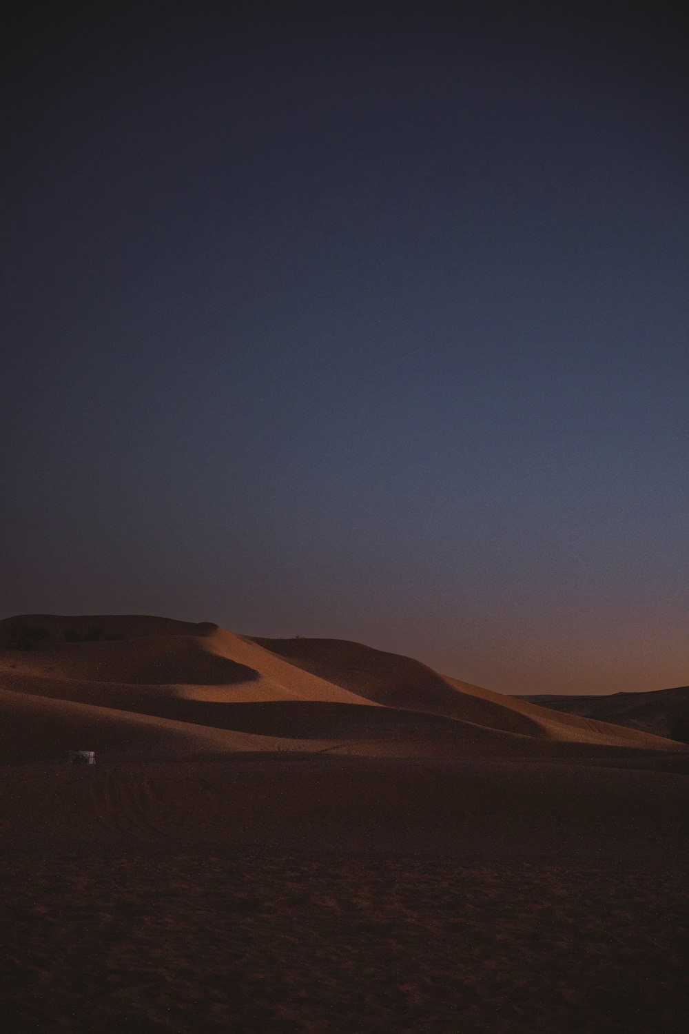 the sun is setting over the sand dunes