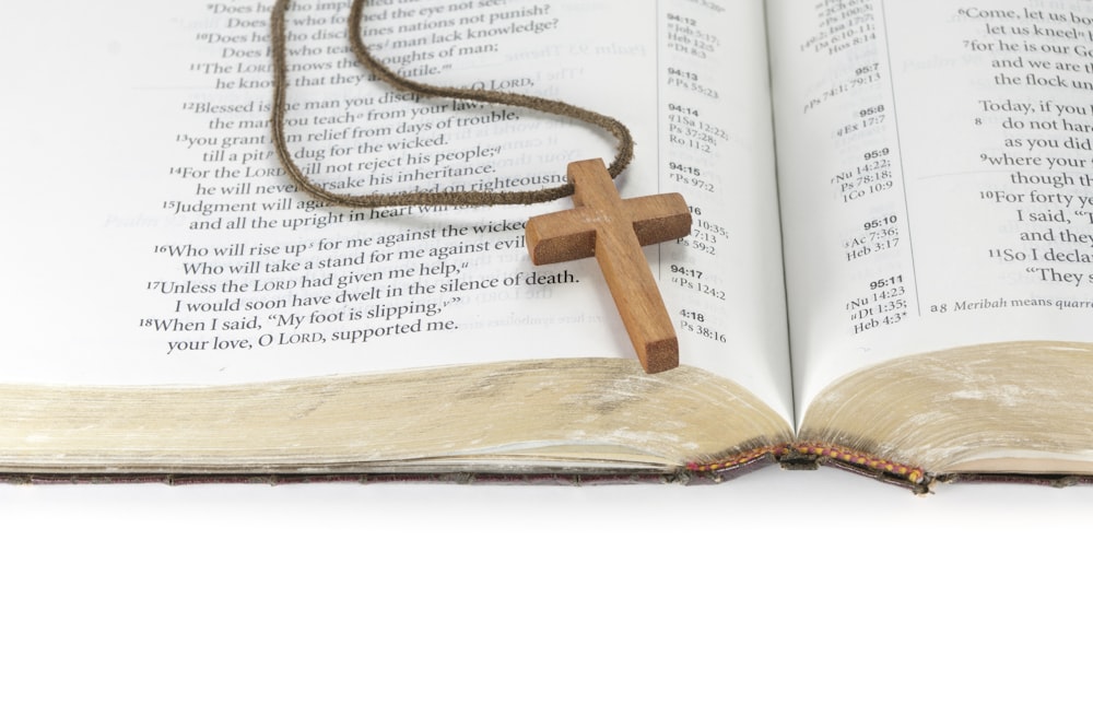 an open book with a wooden cross on it