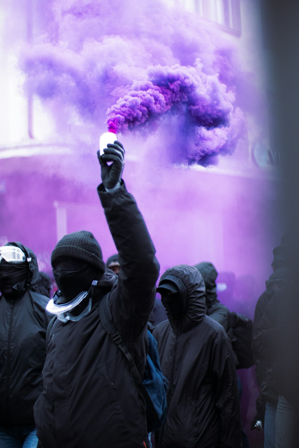 紫色の煙爆弾の前に立つ人々のグループ