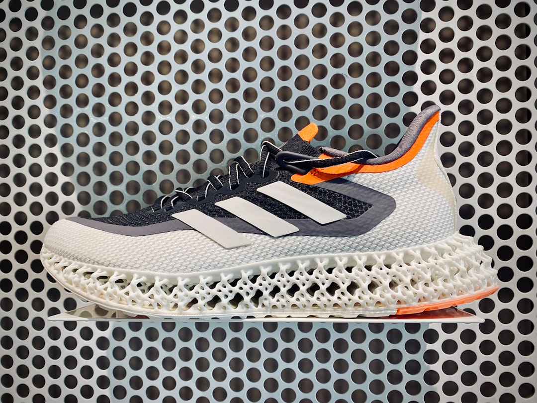 a pair of shoes that are on top of a metal grate, This shoe goes by the name of 4D FWD 2M, apparently parts of it are 3d-printed.