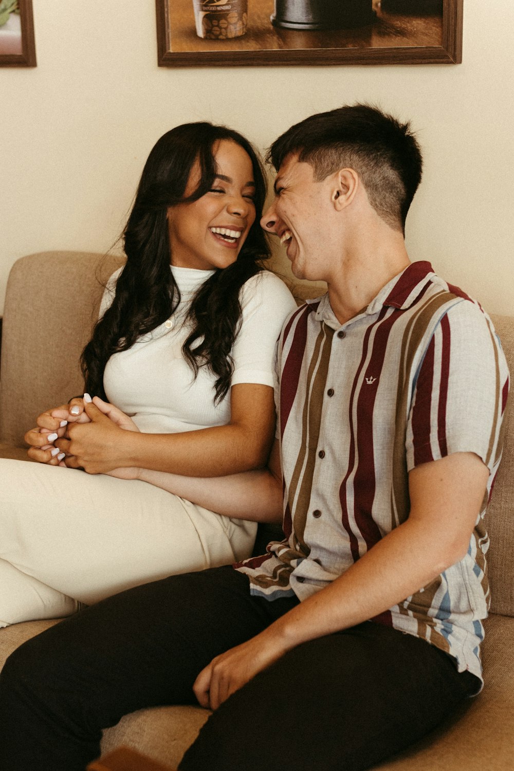 a man and woman sitting on a couch laughing